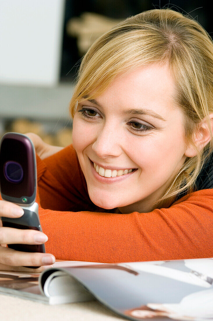 Close-up of a young woman using a mobile phone and smiling