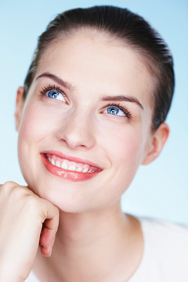 Portrait of young smiling woman looking up