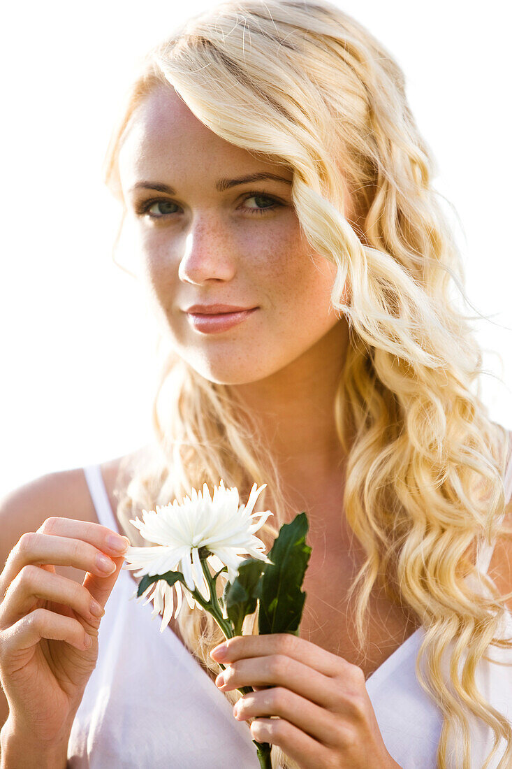 Junge Frau hält eine weiße Blume