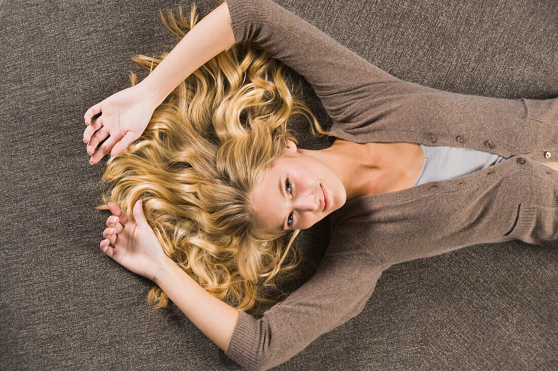 Woman lying on a round sofa and smiling