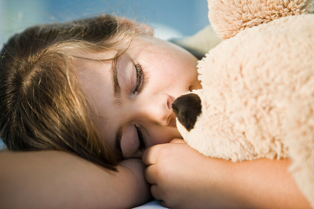 Close-up of a girl sleeping with a teddy bear