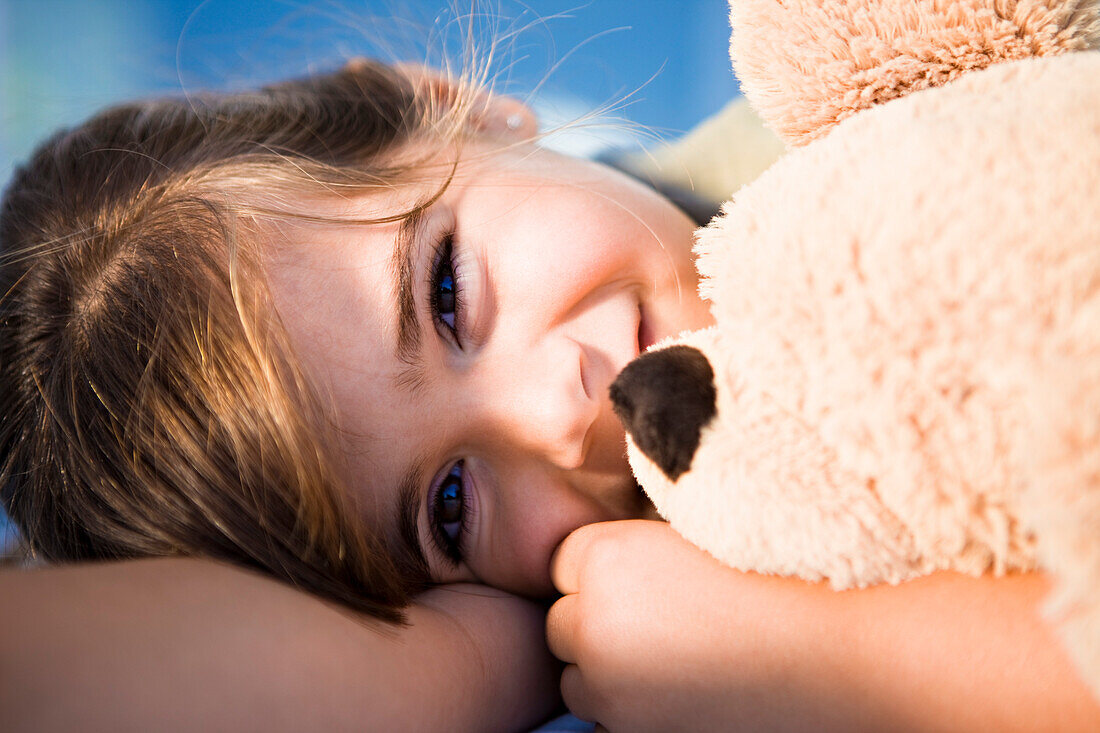 Girl cuddling teddy bear