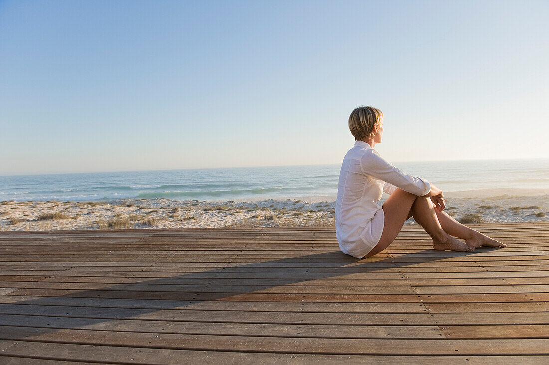 Woman sitting on a boardwalk