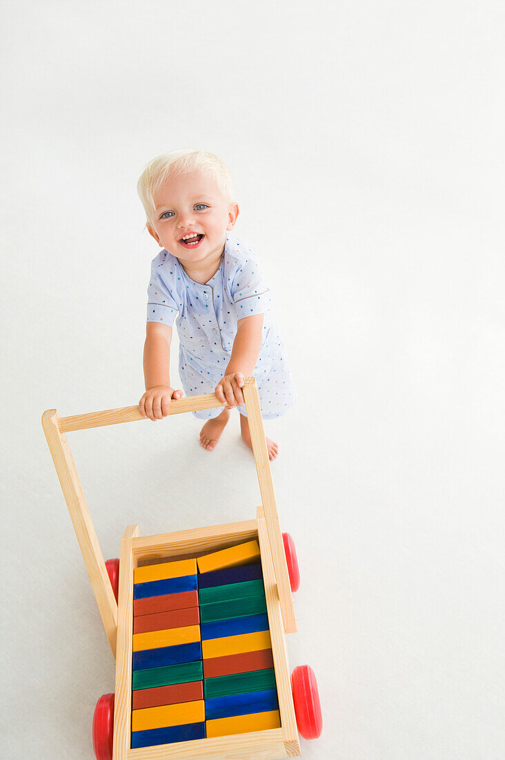 Baby boy pushing a cart