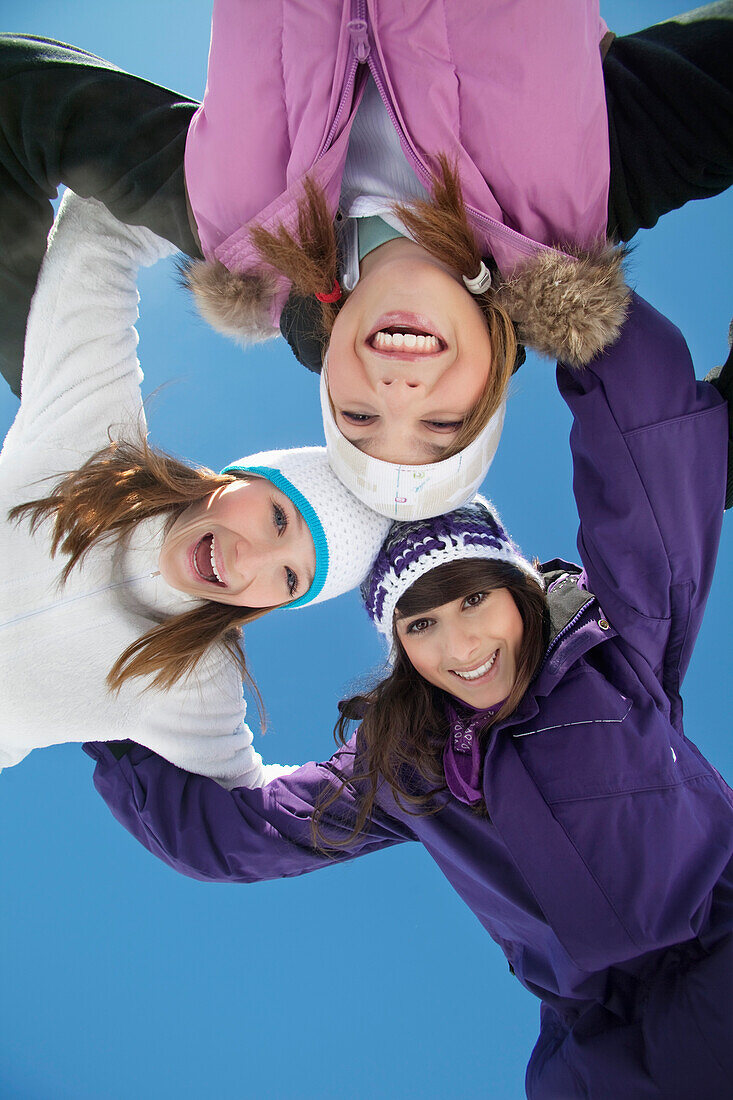 Three teenage girls in ski clothes, smiling at camera
