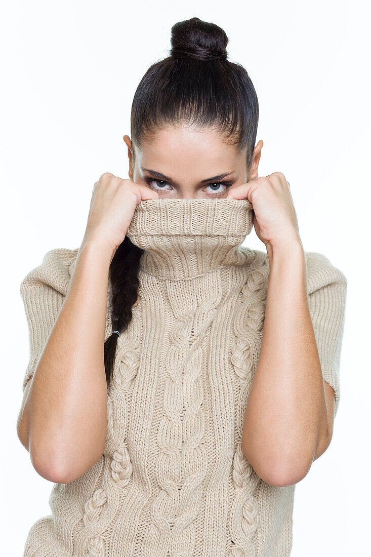 Young woman covering her face with sweater