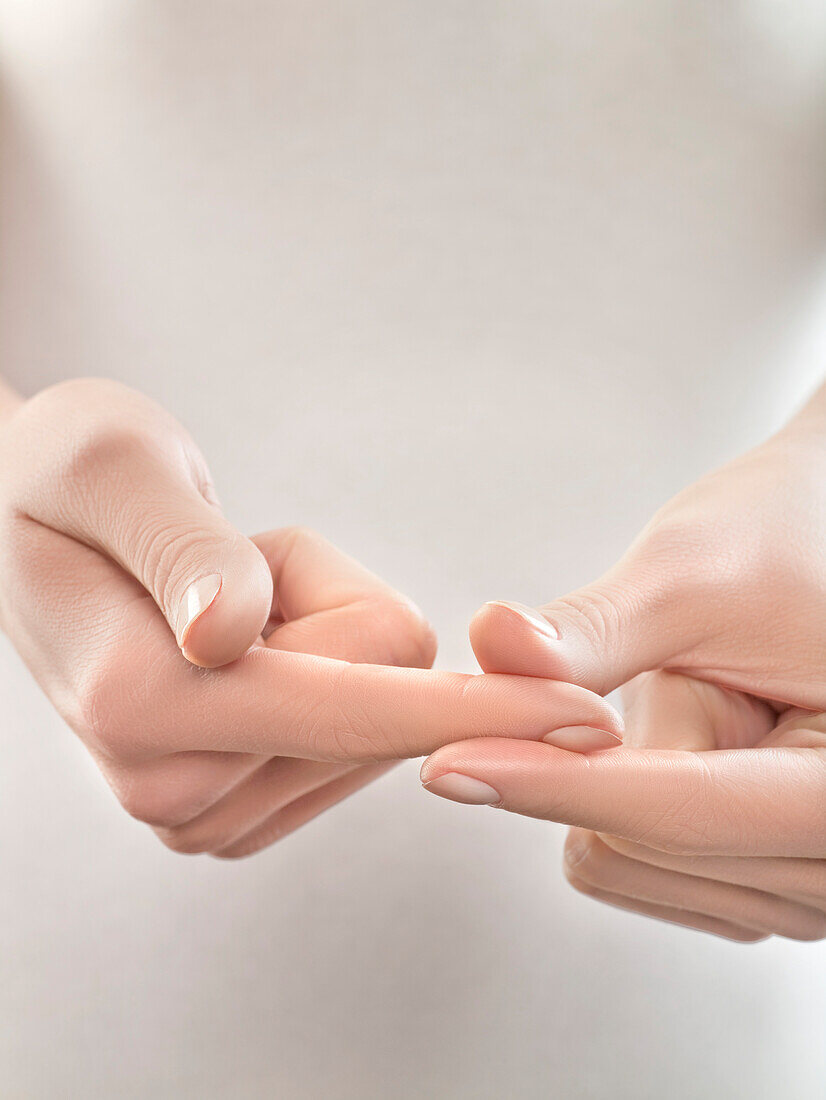 Woman pinching finger, close-up