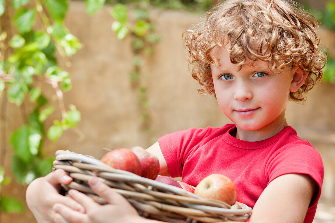 Boy holding basket of apples