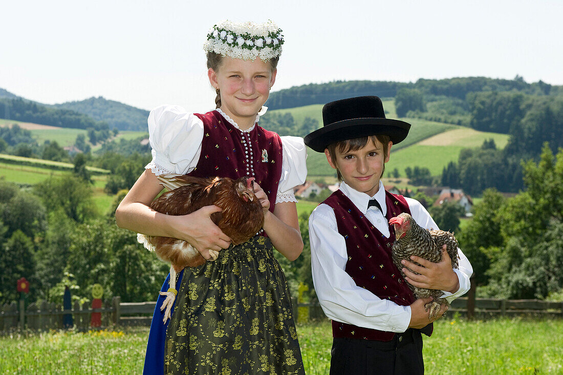 Two children (10-13 years) wearing traditional Black Forest clothes, Gottertal, Baden-Wurttemberg, Germany