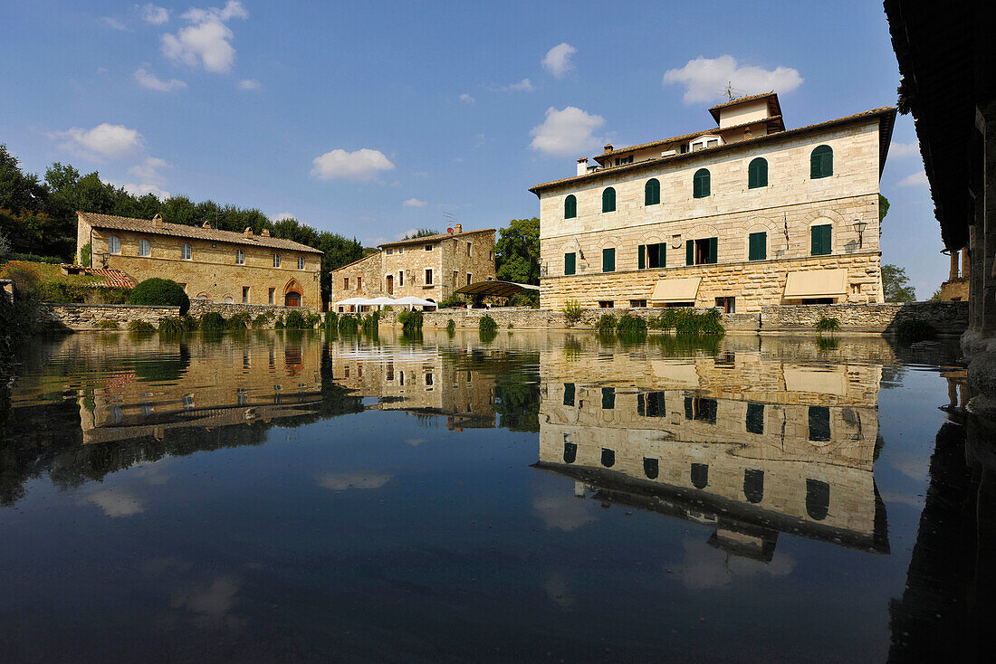 Reflection of houses in a large water basin, Bagno Vignoni, Tuscany, Italy, Europe