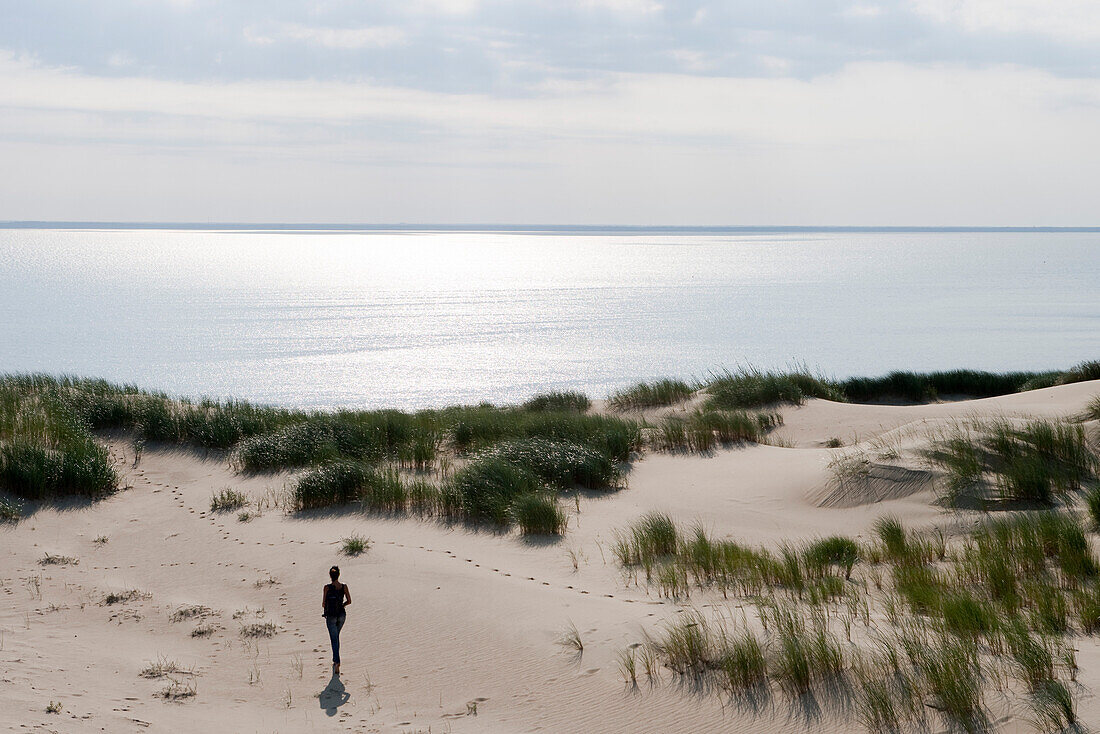 Junge Frau spaziert entlang Düne, Kurische Nehrung, nahe Klaipeda, Litauen, Europa