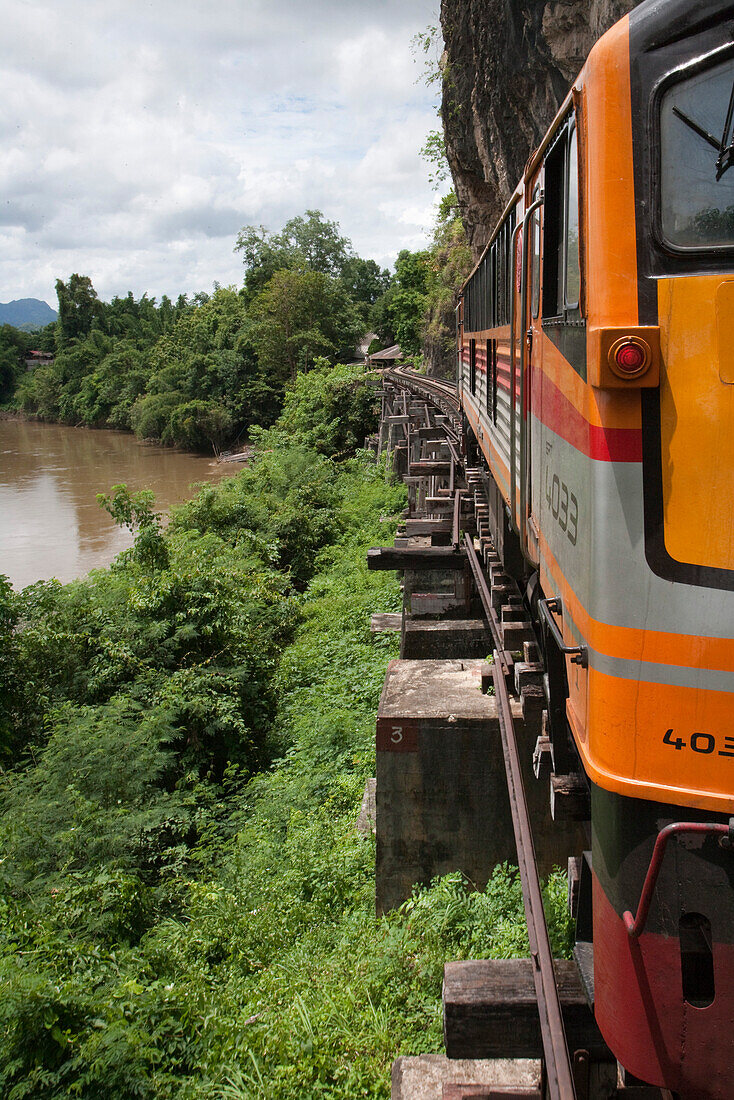 Modern locomotive of tourist train on wooden trestle viaduct of Trans River Kwai Death Railway at Saphan Tham Krasae, near Kanchanaburi, Thailand