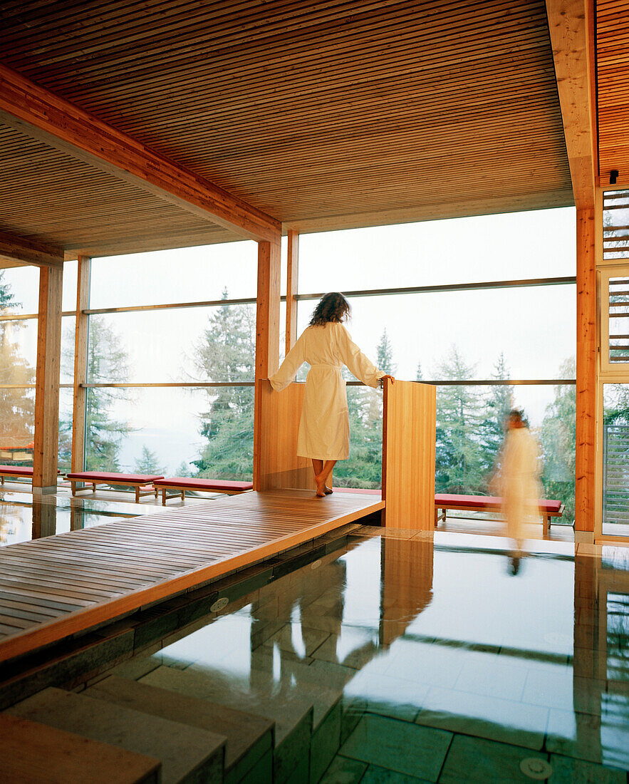 Paar am Innenpool vor Panoramafenster, Vigilius Mountain Resort, Vigiljoch, Lana, Trentino-Südtirol, Italien