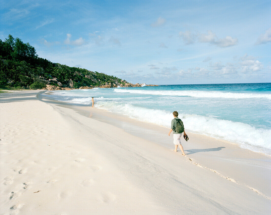 Frau am Strand Petite Anse, südostliches La Digue, La Digue and Inner Islands, Republik Seychellen, Indischer Ozean