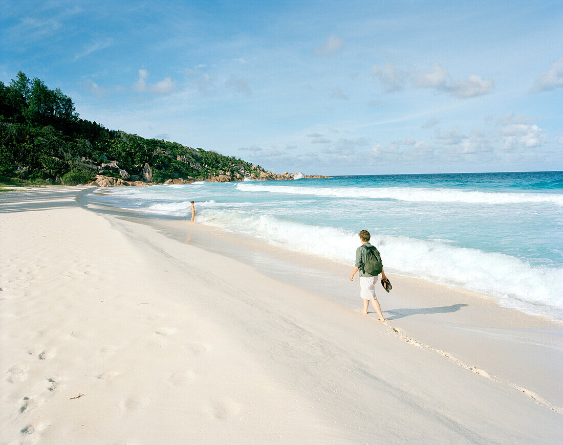 Woman on the beach Petite Anse, south eastern La Digue, La Digue and Inner Islands, Republic of Seychelles, Indian Ocean