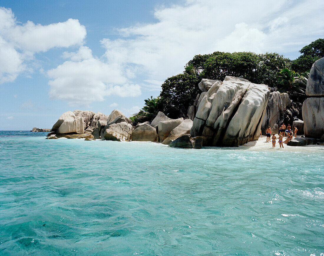 Tourists on the beach of tiny Coco Island, La Digue and Inner Islands, Republic of Seychelles, Indian Ocean