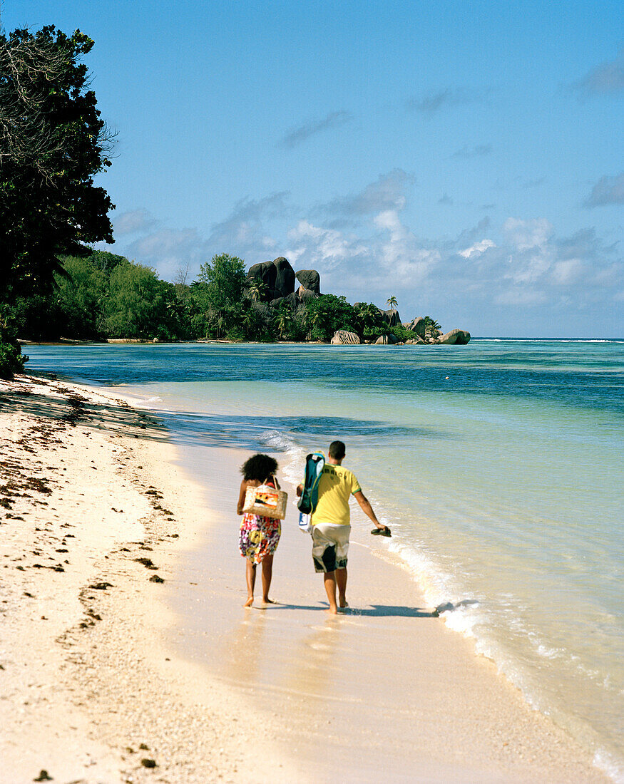 Touristen am Strand L'Union Estate, im Hintergrund der Strand Anse Source d'Argent mit Granitfelsen, südwestliches La Digue, La Digue and Inner Islands, Republik Seychellen, Indischer Ozean