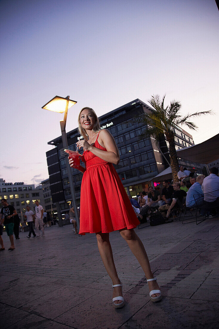 Woman drinking a cocktail outside the Waranga Bar, Kleiner Schlossplatz, Stutttgart, Baden-Wurttemberg, Germany