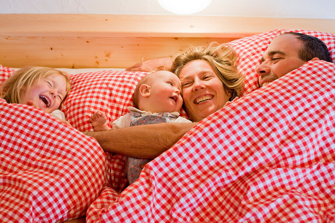 Family lying in bed laughing