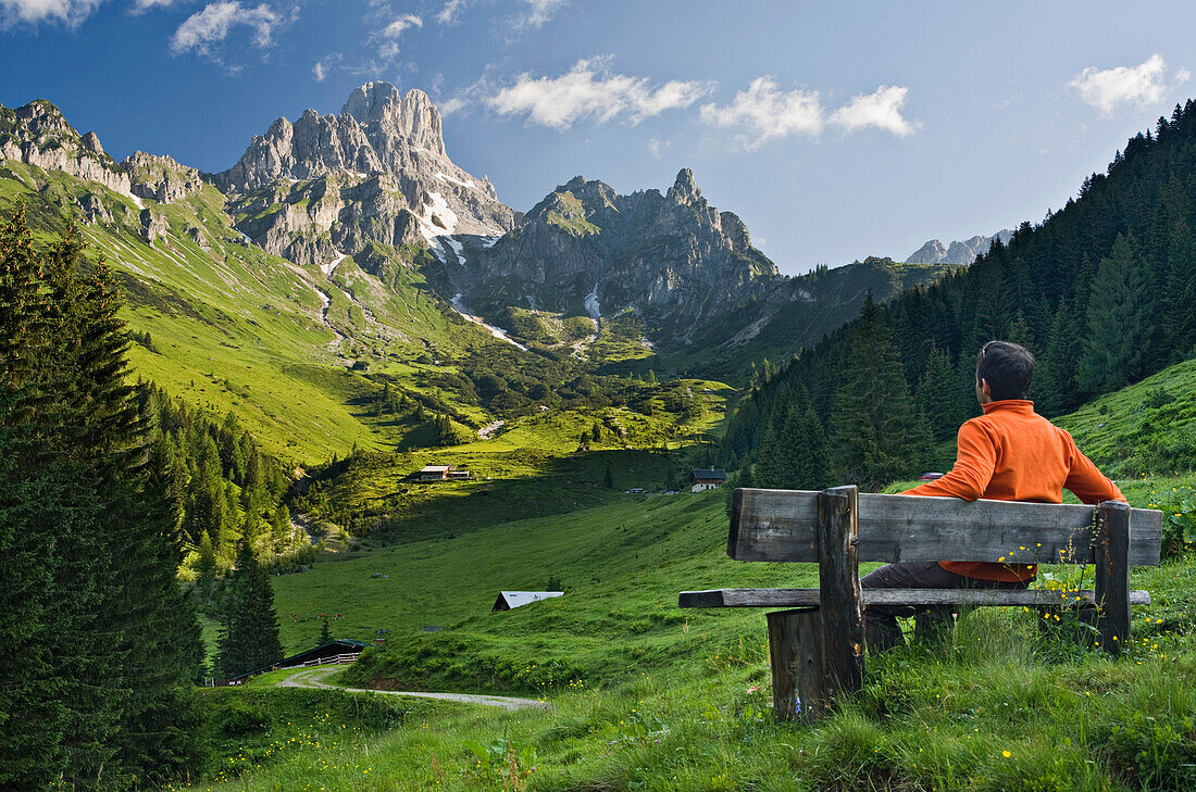 Young man on a bench looking at the view, Hofalm, Bischofsmuetze, Salzkammergut, Salzburg, Austria, Europe