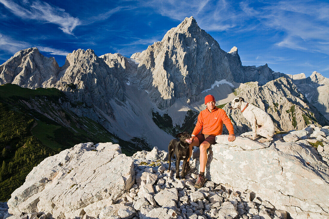 Junger Mann sitzt auf einem Fels, Dachstein, Dachsteingebirge, Salzburg, Österreich, Europa