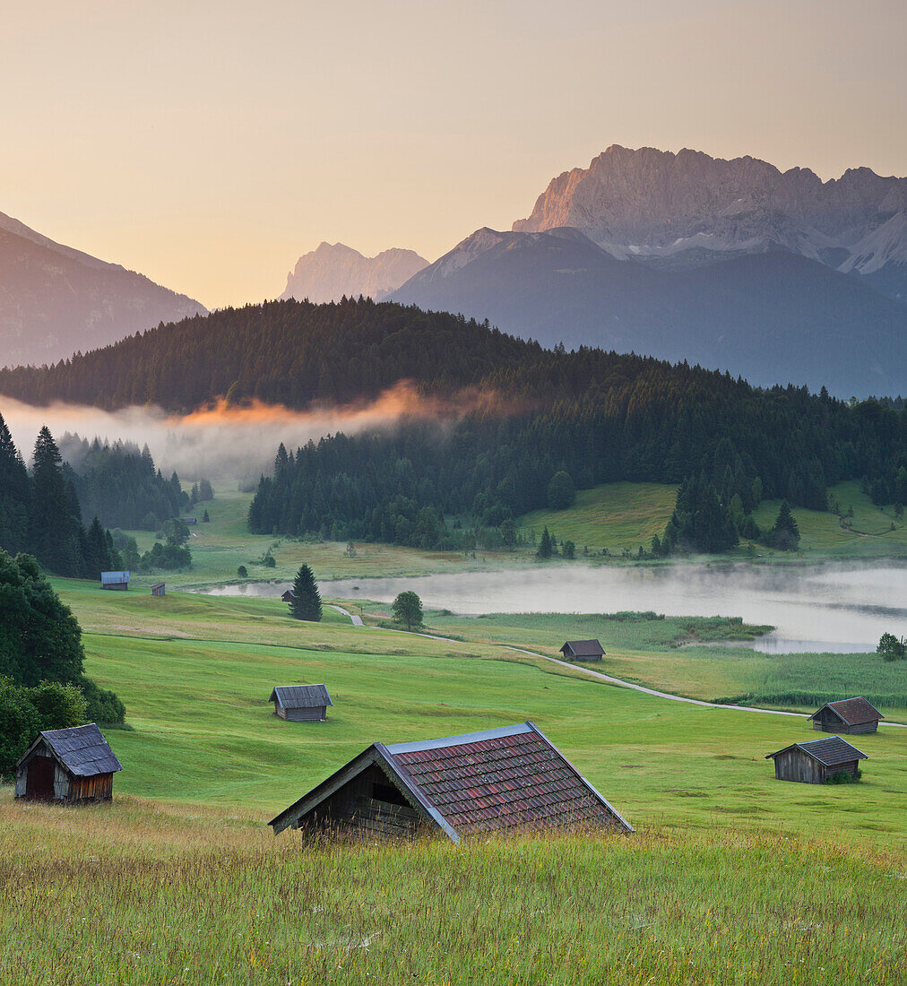 Blick über Wiese mit Hütten und Wagenbrüchsee am Morgen, nördliche Karwendelkette, Bayern, Deutschland, Europa
