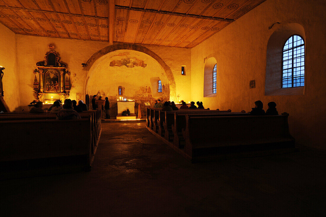 Menschen in der romanischen Kirche St. Veit bei Kerzenlicht, Tartsch, Mals, Vinschgau, Südtirol, Alto Adige, Italien, Europa