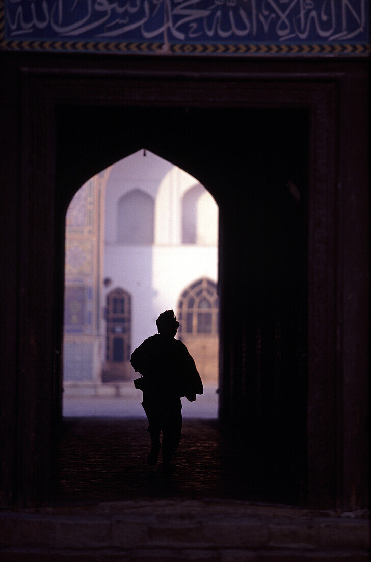 Boy silouhetted against the opening of Mosque, Herat, Afghanistan