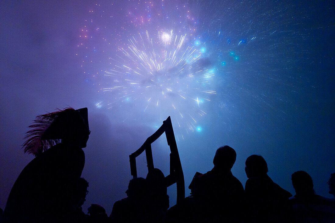 Silhouettes of people watching firework display, Newick, England