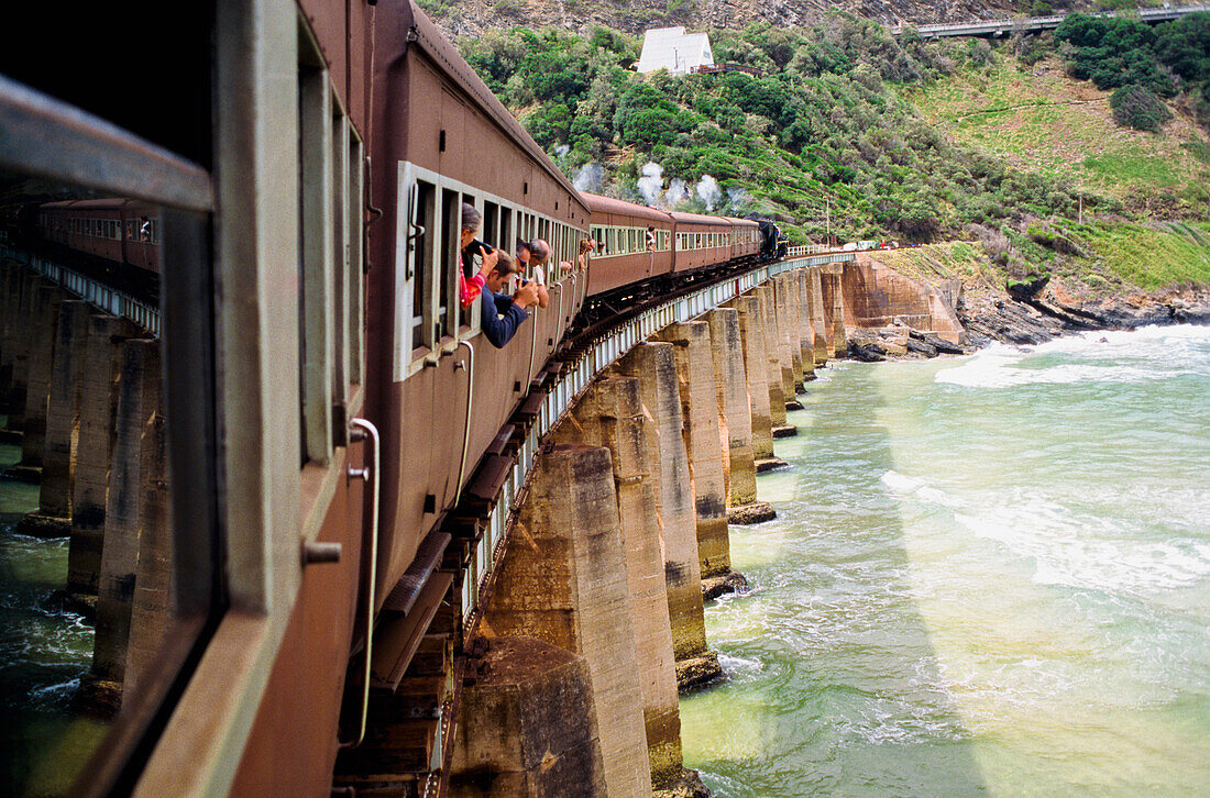 Tourist in windows of steam train on Kaaimans Bridge, Garden Route, South Africa