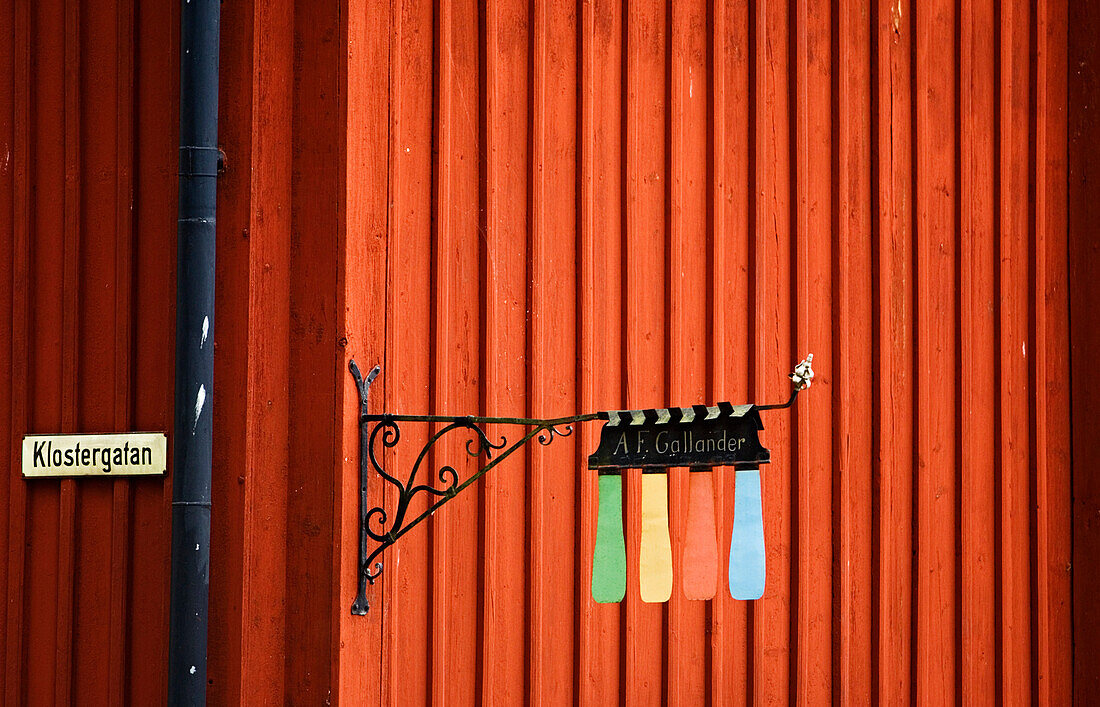 Colourful house sign outside wooden building painted in Falu red, Mariefred, Sweden