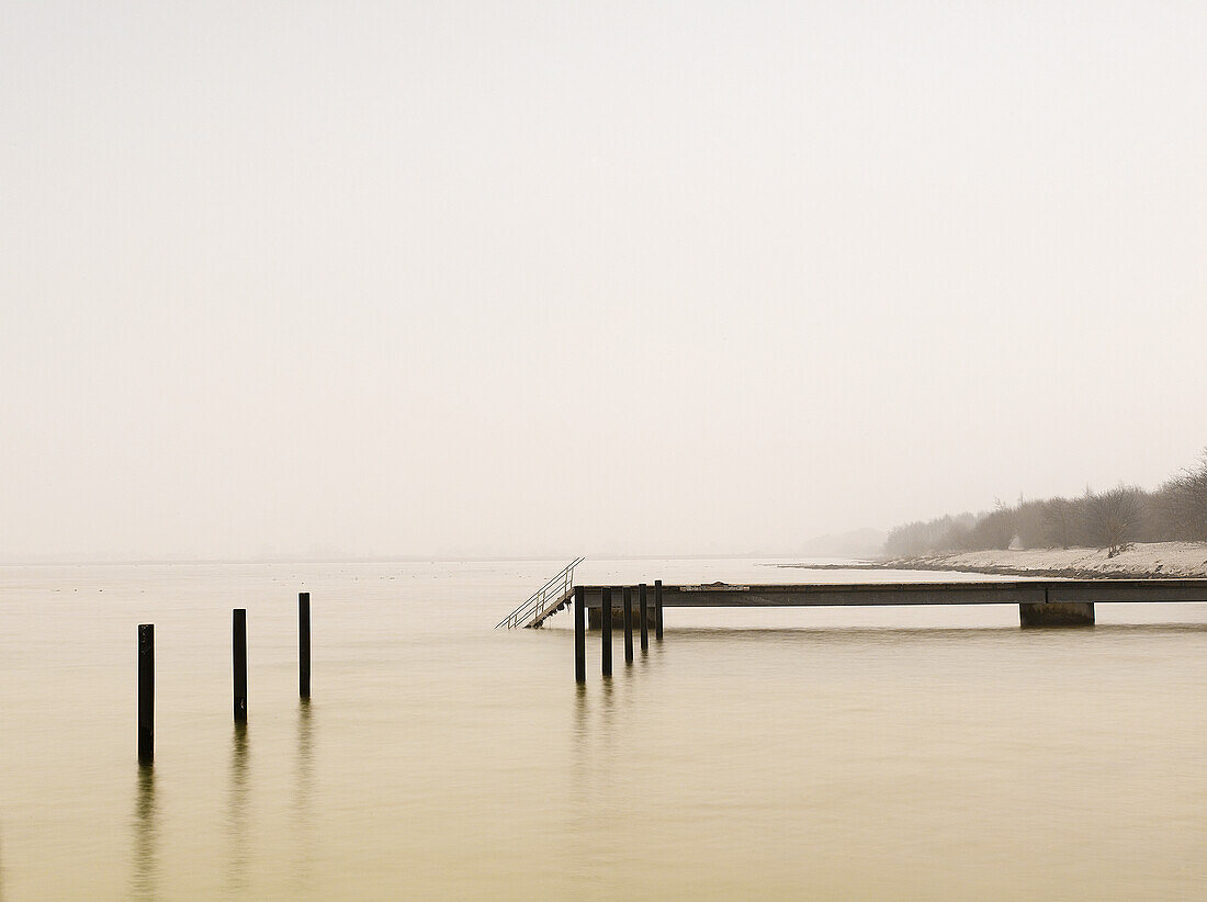 Pier on misty lake at dawn, Sweden