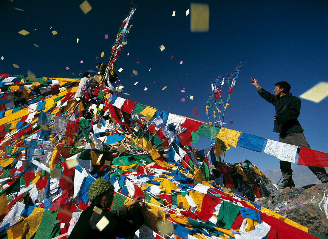 Pilgrim throwing prayer flags, Bompori Hill, Lhasa, Tibet