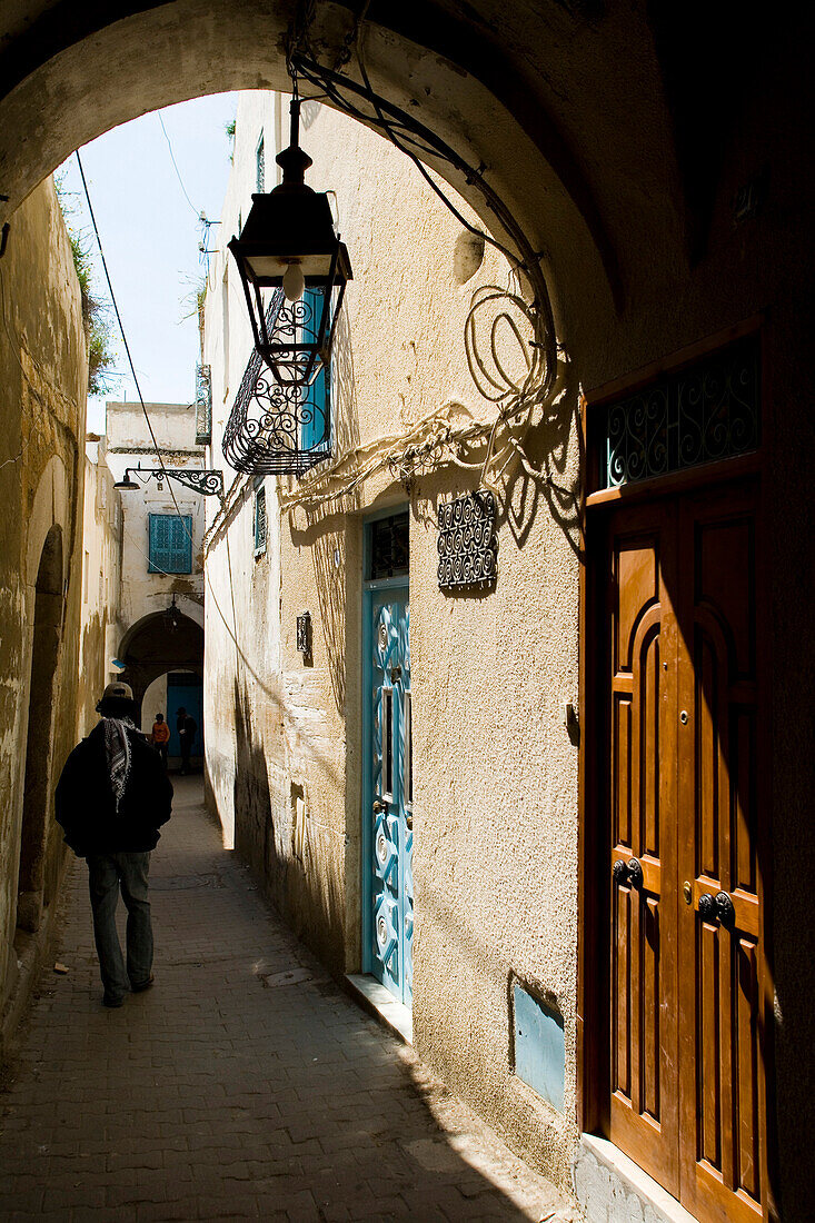 Man walking down a back alley in medina, Tunis, Tunisia