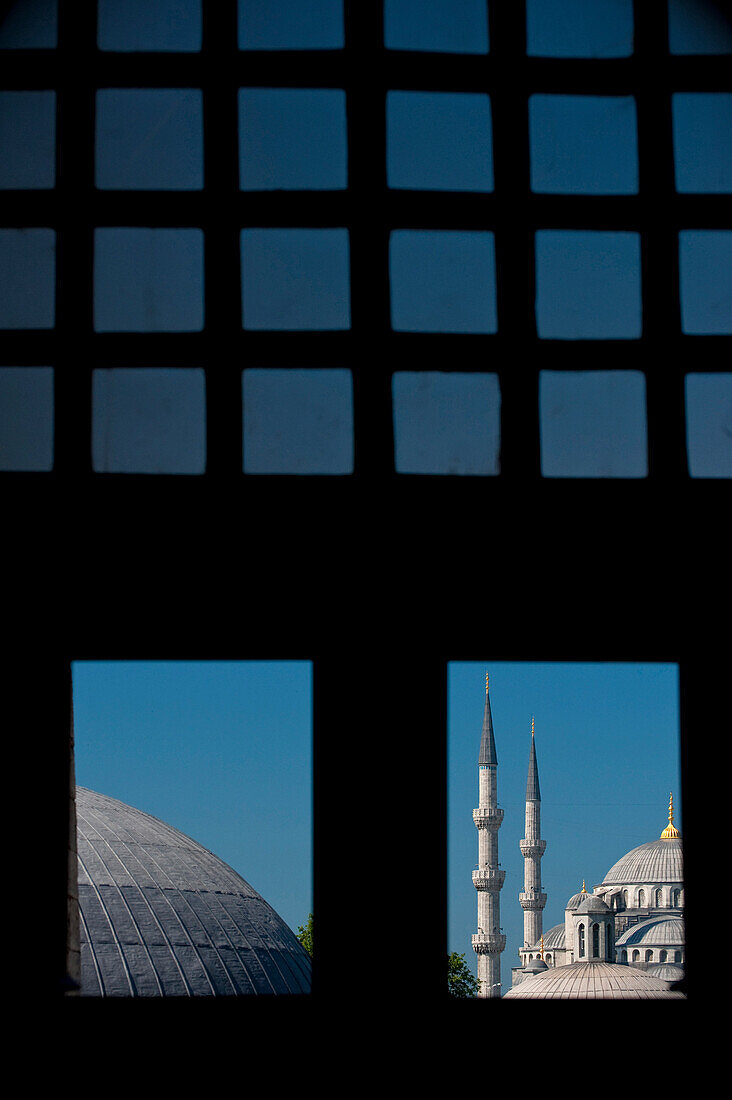 Looking out window and across the domed rooves of the Haghia Sophia to the Sultanahmet or Blue Mosque, Istanbul, Turkey.