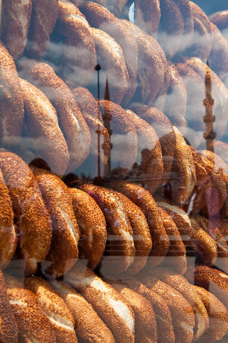 Reflections of the New Mosque in glass of simit bread sellers cart, Istanbul, Turkey.