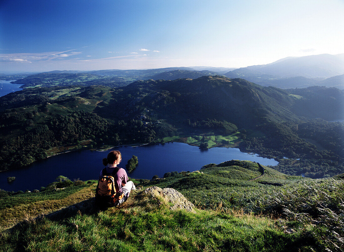 Walker resting above Rydal Water, Lake District, Cumbria, England