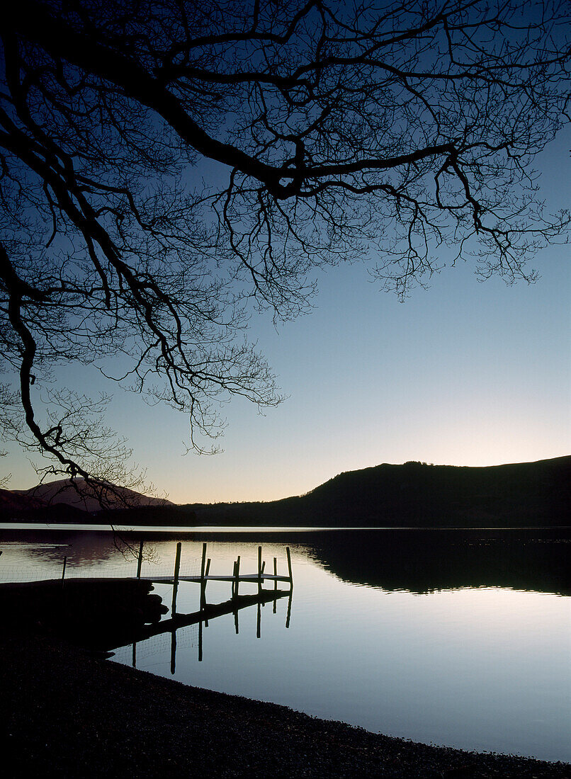 Silhouette of pier on lake at Derwent Water, Lake District, Cumbria, England
