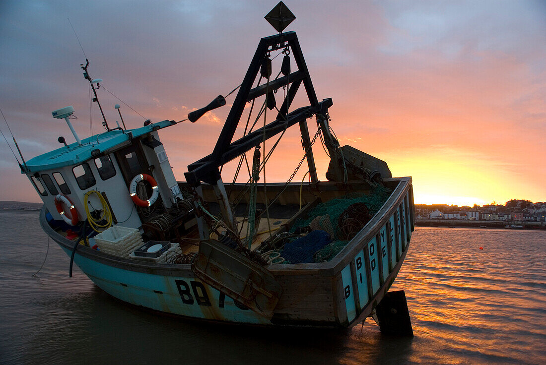 Fishing boat on the shore at sunset, Appledore, North Devon, England