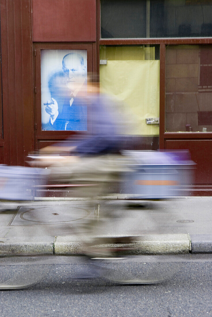 France, Paris, cyclist, portrait of Sigmund Freud in background