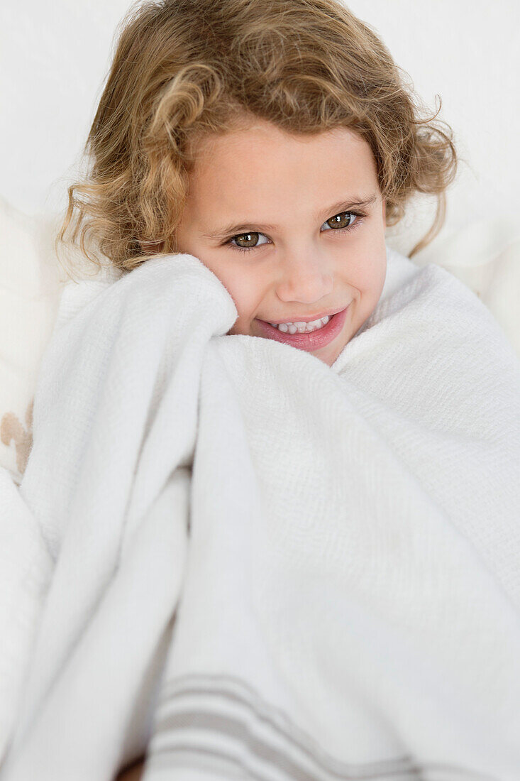 Cute little girl wrapped in a white towel