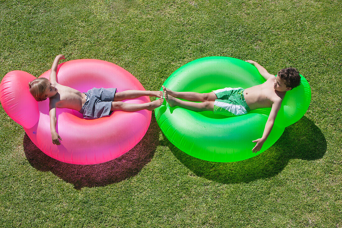 Two boys relaxing on inflatable rings
