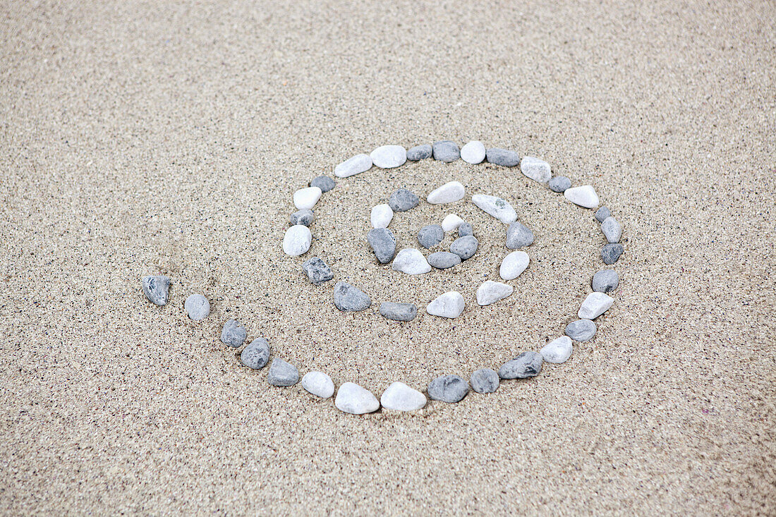 Pebbles arranged in spiral shape on beach