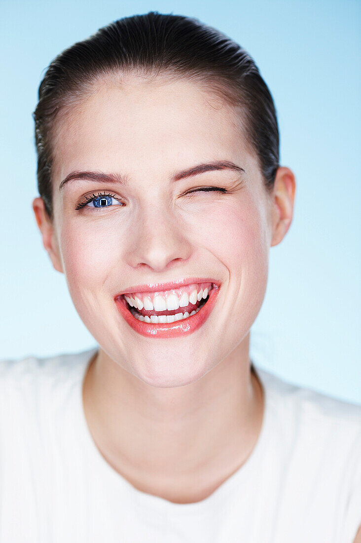 Portrait of young smiling woman winking