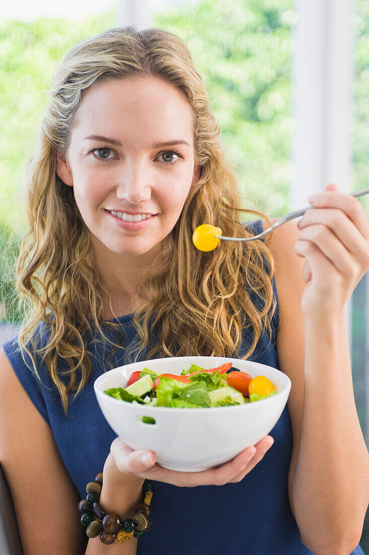 Portrait of a woman eating fruit salad