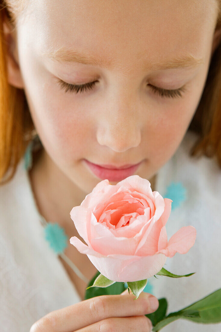 Close-up of a flower girl smelling a flower