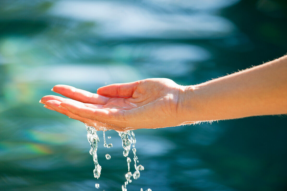 Close-up of a man's hand touching the water of the swimming pool