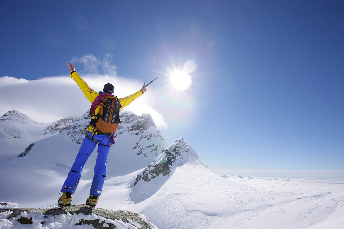 Mountaineer at the summit of Jungfraujoch, Jungfrau in the background, Grindelwald, Bernese Oberland, Switzerland