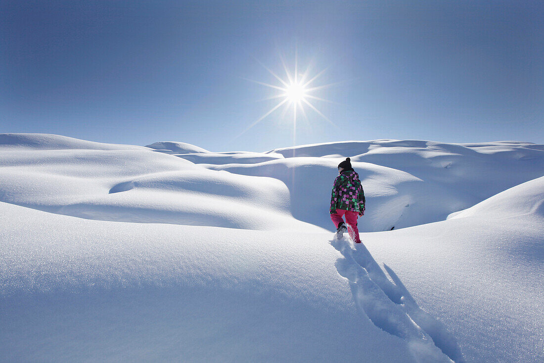 Junges Mädchen stapft durch tiefen Schnee, Klösterle, Arlberggebiet, Österreich