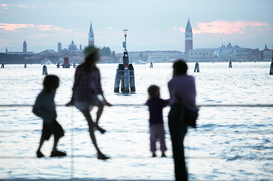 Family at Lido wharf, view to Venice, Veneto, Italy